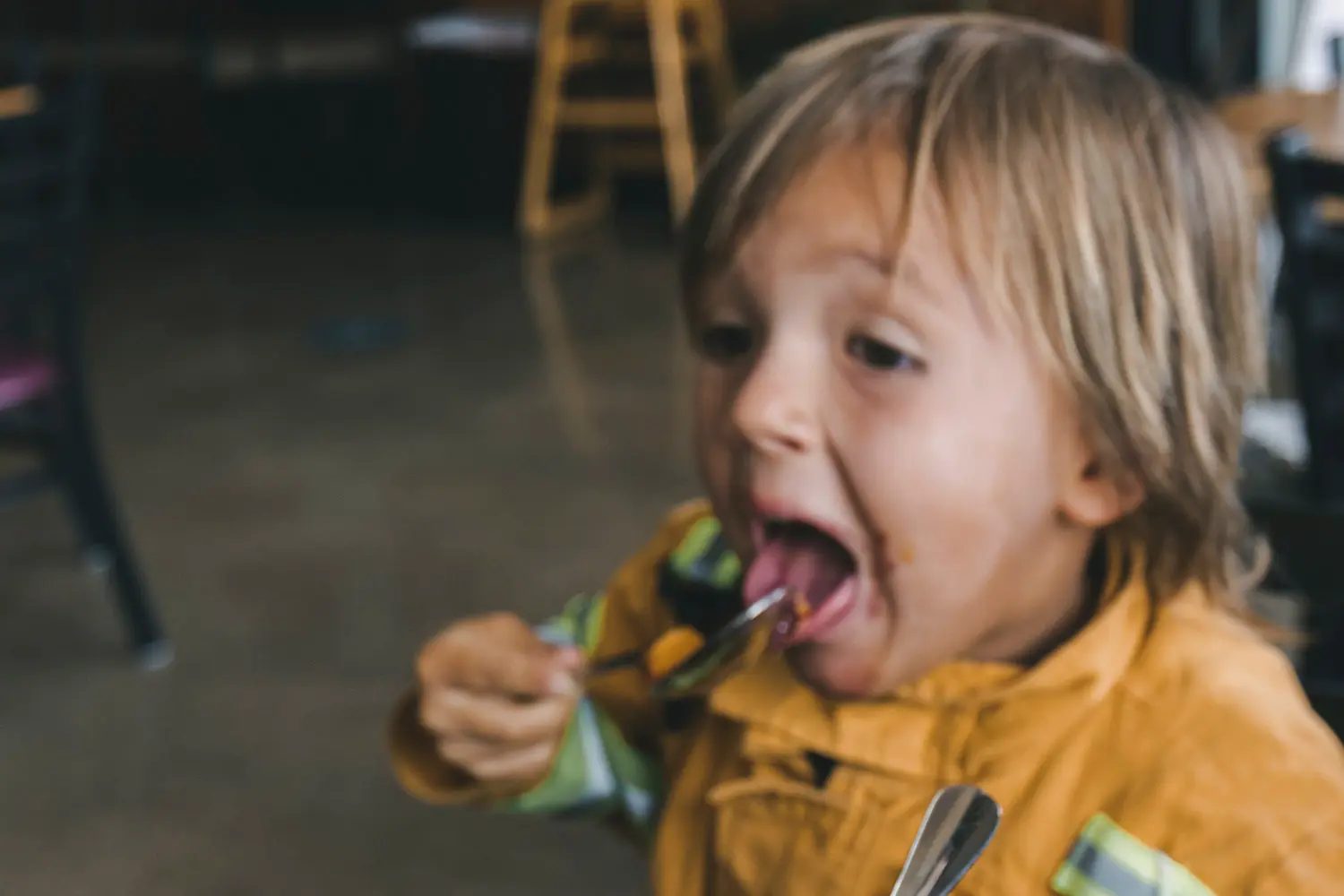 Boy eating food on a spoon