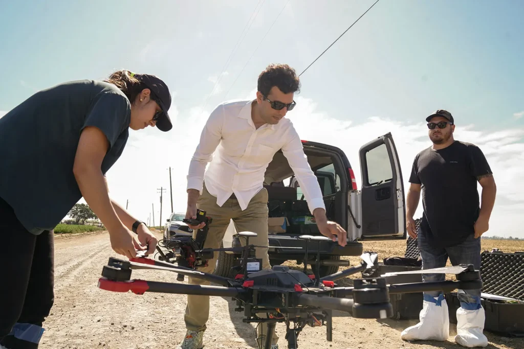 Three people prepping a drone for flight