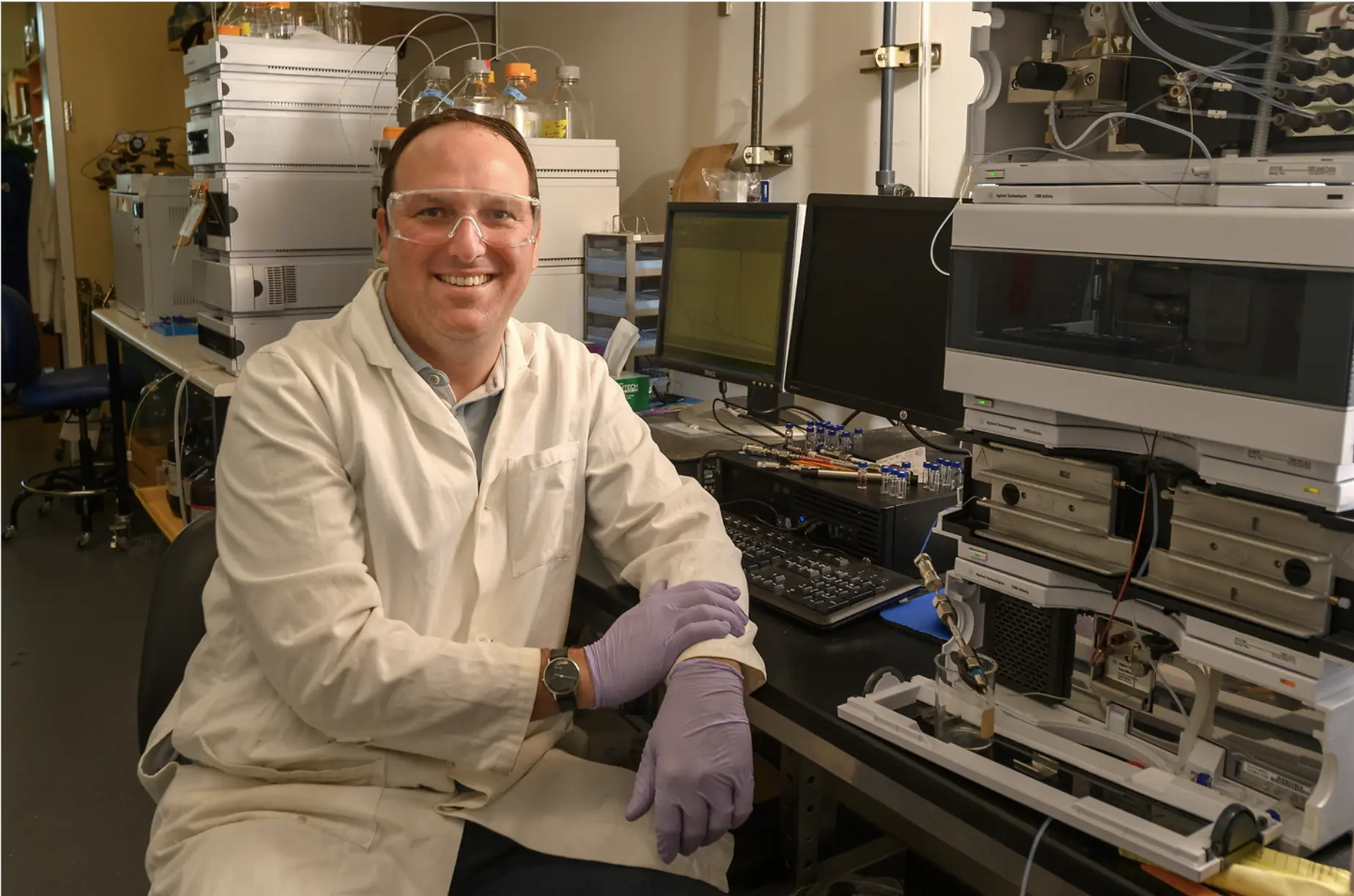 Scientist sitting in a room full of scientific testing machines