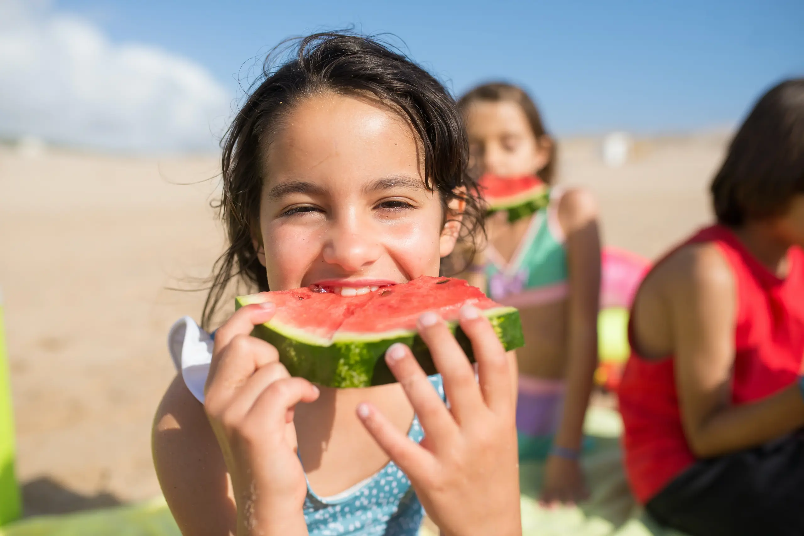 Girl taking a bite of watermelon