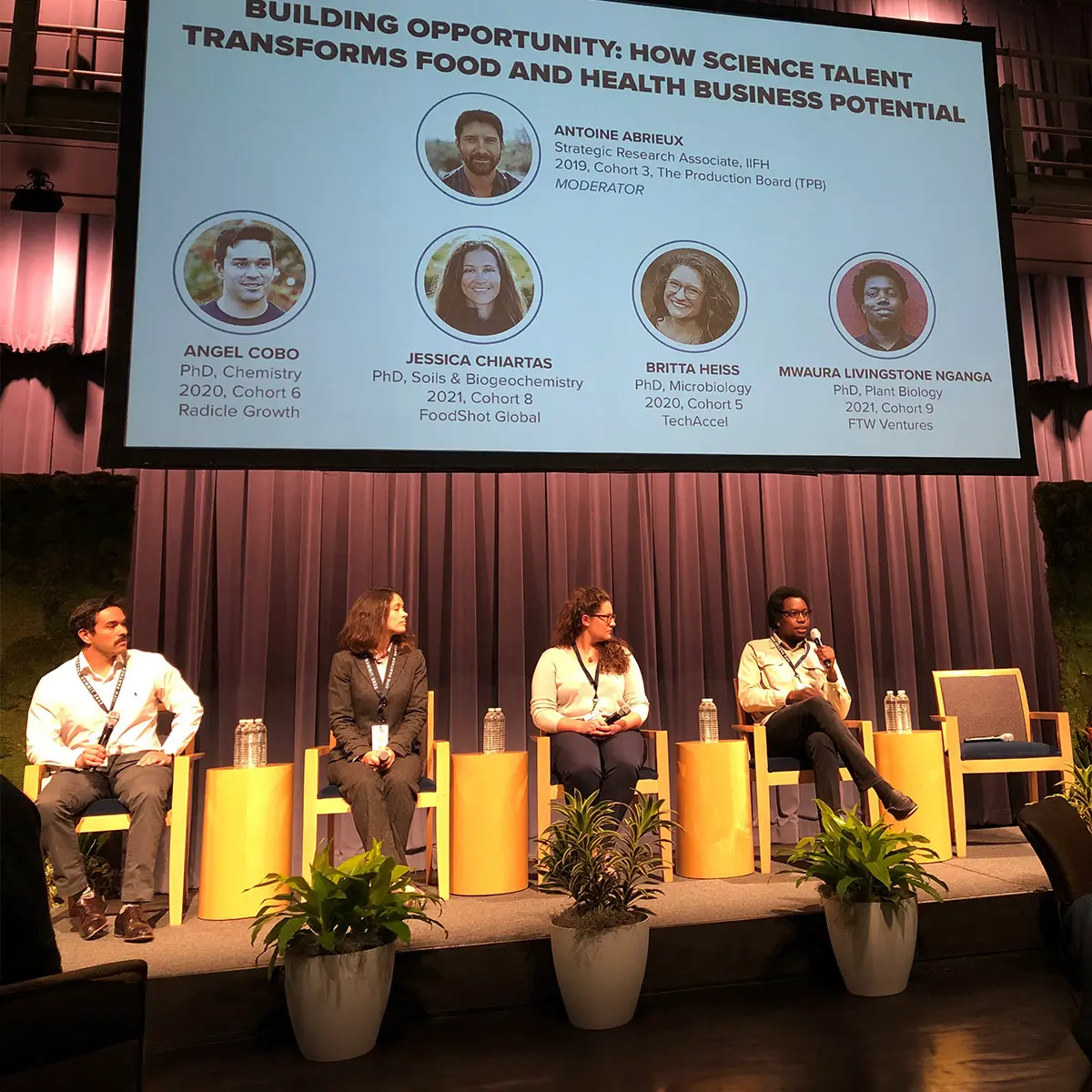 Speakers sitting on a stage at an event