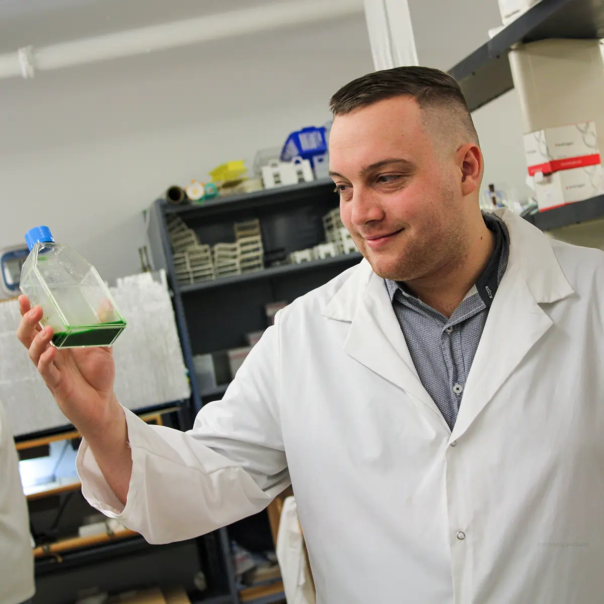 Scientist holding bottle with green fluid