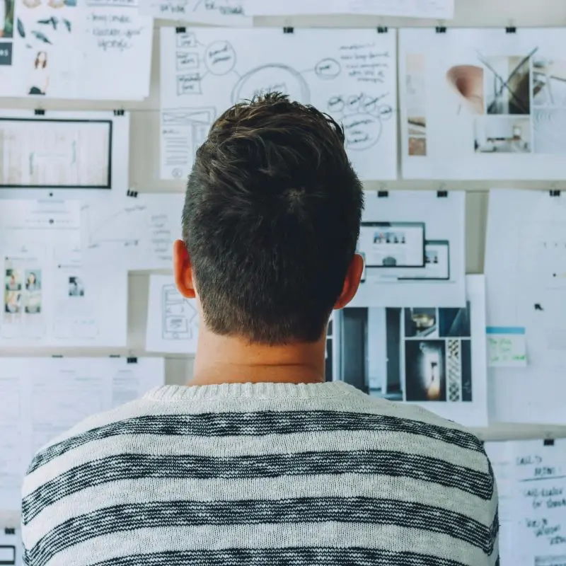 Man looking at notes on a wall