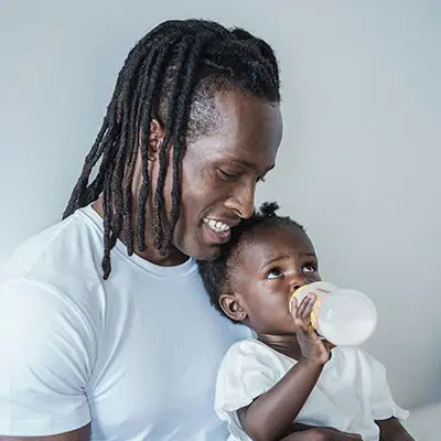 Man holding a baby drinking from bottle