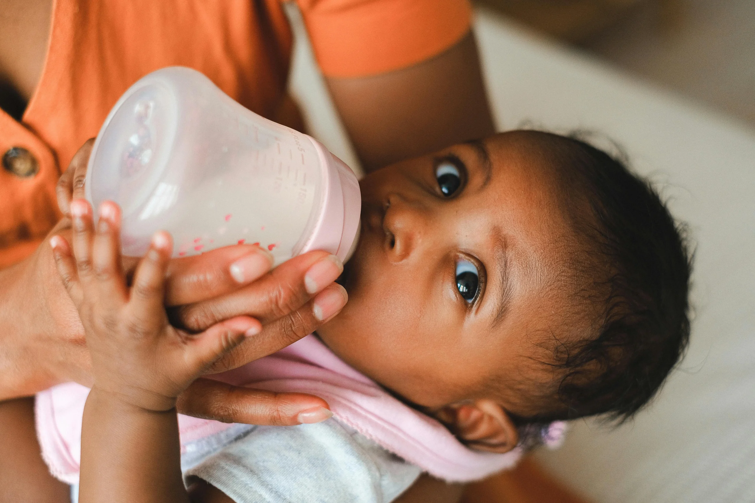 Infant being bottle fed milk
