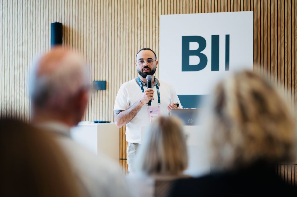 fellow speaking into microphone BII
