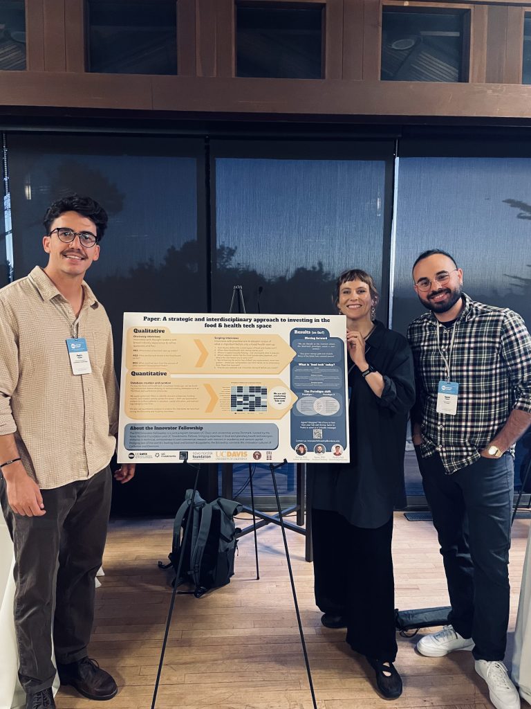 Three fellows by a poster