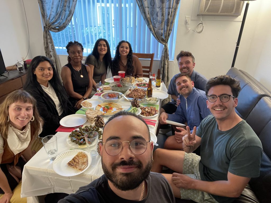 Fellows around a table with other students